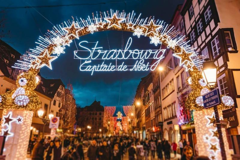 Marché de Noël traditionnel français avec des chalets illuminés et des visiteurs